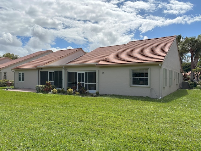 back of house with a patio, a yard, a tiled roof, and stucco siding