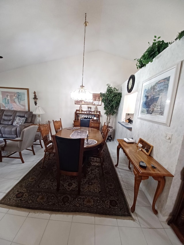 dining area featuring light tile patterned flooring and vaulted ceiling