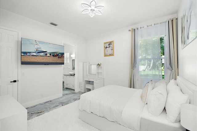 bedroom with visible vents and ensuite bath