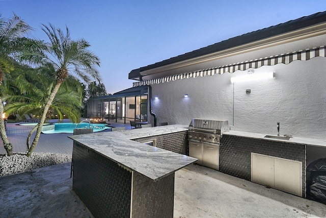 view of patio featuring a sink, area for grilling, a grill, and an outdoor pool