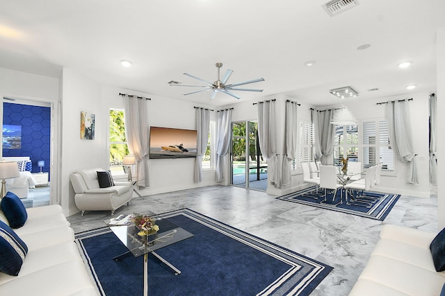 living room with plenty of natural light, visible vents, marble finish floor, and a ceiling fan