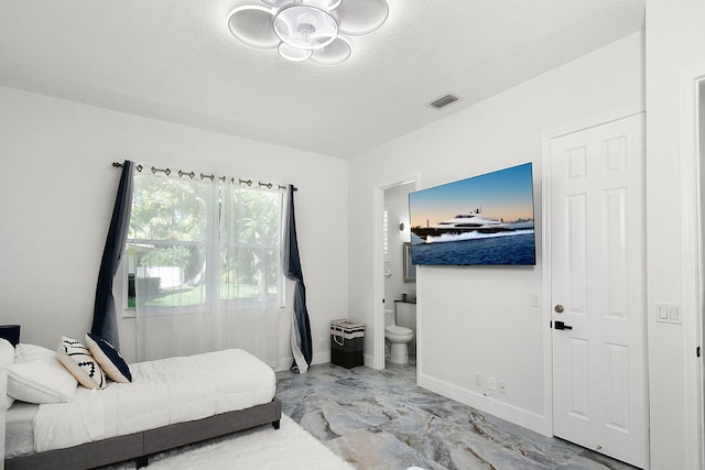 bedroom with visible vents, baseboards, ensuite bath, marble finish floor, and a textured ceiling