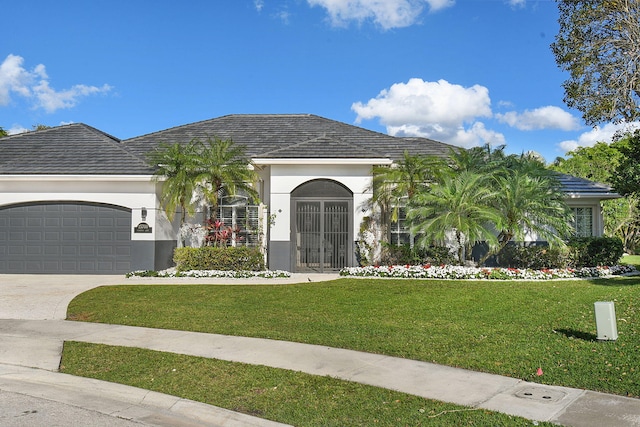 view of front of property with an attached garage, concrete driveway, stucco siding, and a front lawn