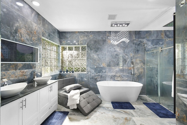 full bath with a sink, visible vents, tile walls, and a shower stall