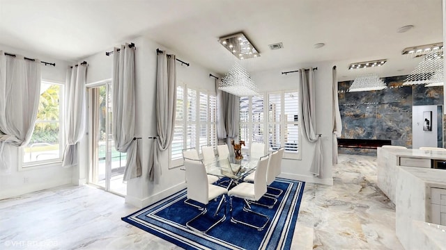 dining space with a fireplace, marble finish floor, and baseboards