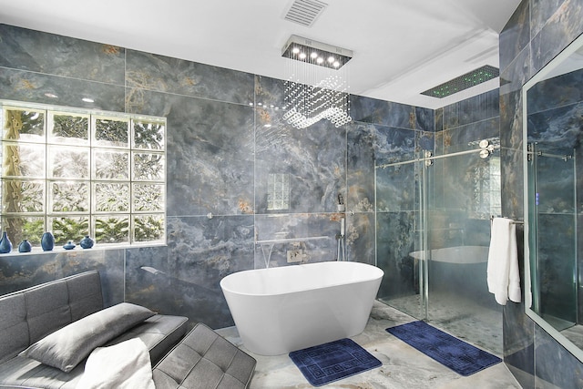 full bathroom featuring marble finish floor, tile walls, a soaking tub, visible vents, and a stall shower