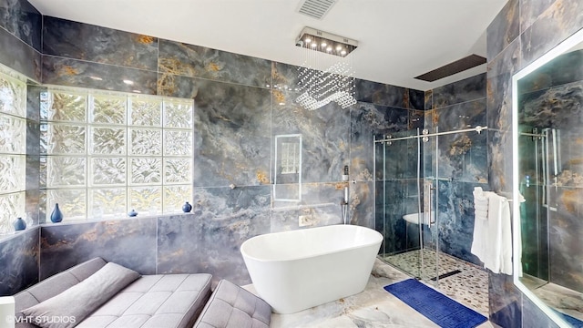 full bathroom featuring a freestanding tub, visible vents, tile walls, and a tile shower