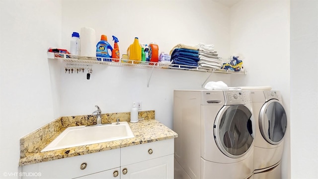 washroom featuring a sink, cabinet space, and washer and dryer