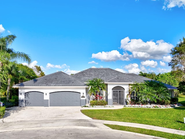 view of front facade featuring a front yard, driveway, an attached garage, and stucco siding