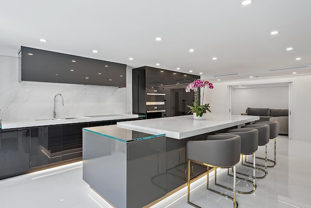 3140 S Ocean Blvd S Unit 502S, Palm Beach, FL 33480 - kitchen featuring a breakfast bar area, a spacious island, a sink, light countertops, and modern cabinets