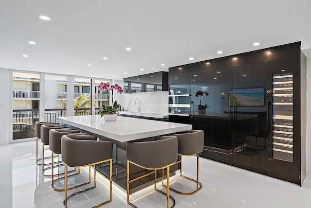 3140 S Ocean Blvd S Unit 502S, Palm Beach, FL 33480 - kitchen featuring a large island, a kitchen breakfast bar, dark cabinets, and a sink