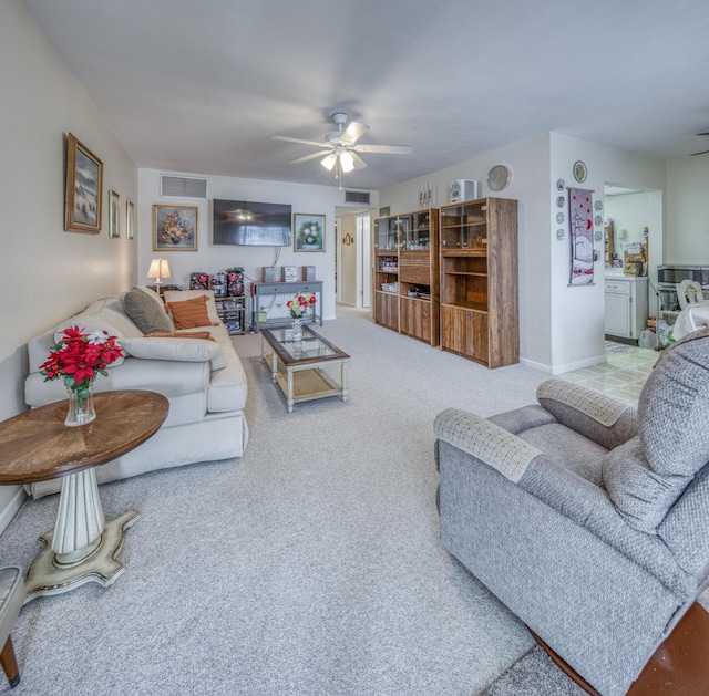 carpeted living area with visible vents, ceiling fan, and baseboards