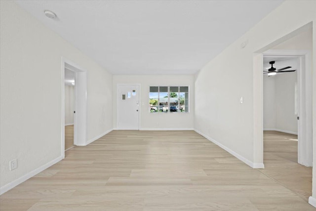 unfurnished room featuring baseboards and light wood finished floors