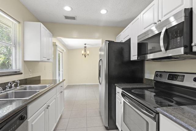 kitchen with light tile patterned floors, a sink, visible vents, white cabinets, and appliances with stainless steel finishes