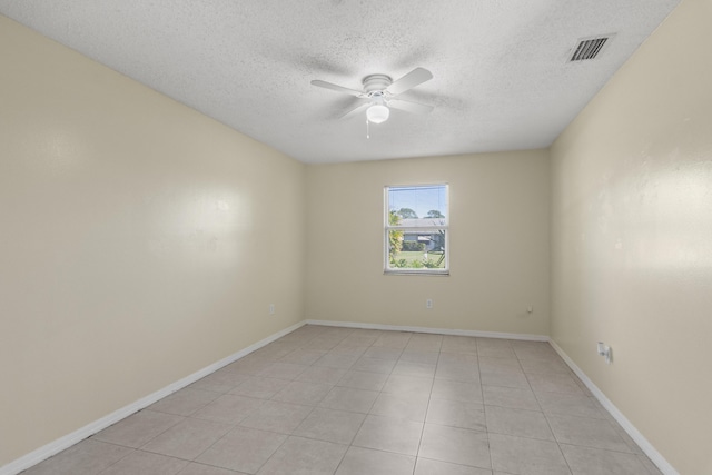 spare room with ceiling fan, a textured ceiling, visible vents, and baseboards