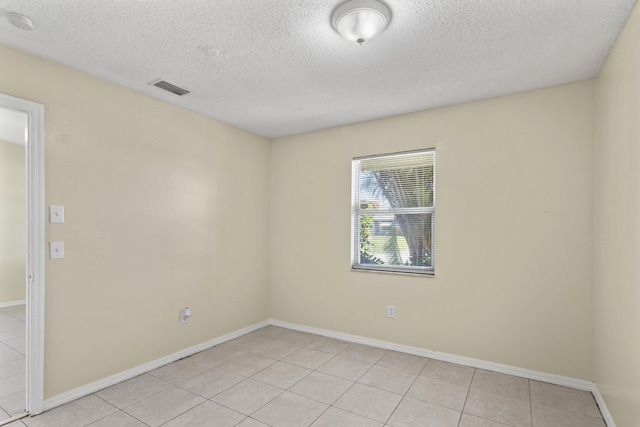 unfurnished room with light tile patterned floors, visible vents, and baseboards