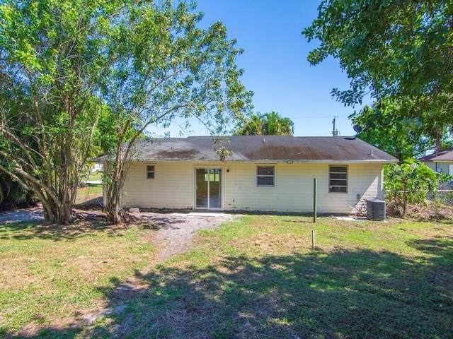 back of house with a lawn, fence, and central air condition unit