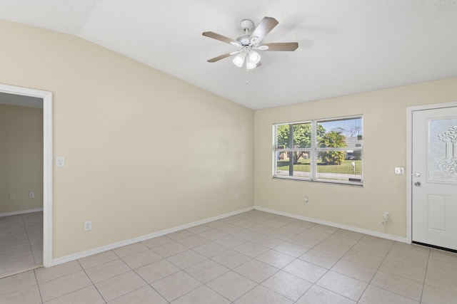 unfurnished room with vaulted ceiling, light tile patterned floors, a ceiling fan, and baseboards