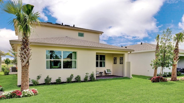 rear view of house featuring central air condition unit, a yard, a patio, and stucco siding