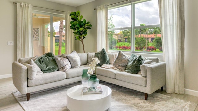 living area with baseboards and wood finished floors