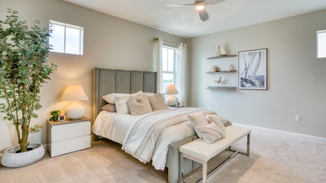 bedroom featuring light carpet, baseboards, and a ceiling fan