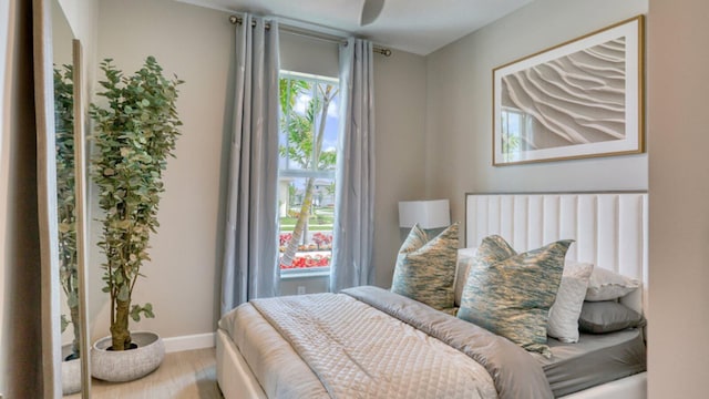 bedroom with baseboards and wood finished floors