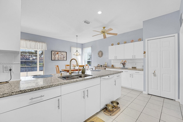 kitchen with white cabinetry, a sink, dishwasher, and light stone countertops