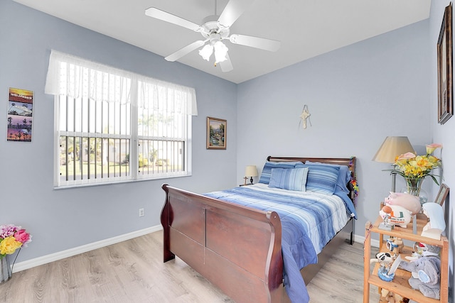 bedroom with ceiling fan, wood finished floors, and baseboards