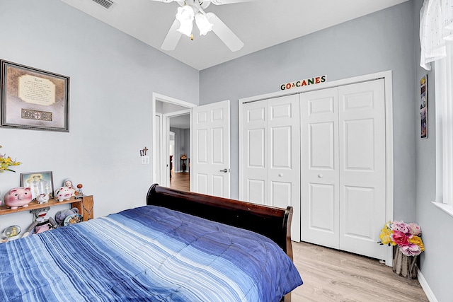 bedroom featuring baseboards, a closet, a ceiling fan, and light wood-style floors