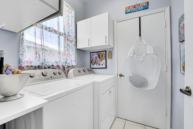 laundry room with washer and clothes dryer, light tile patterned flooring, and cabinet space