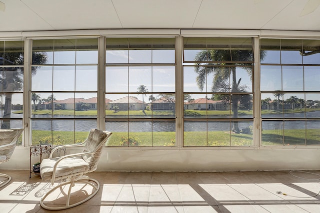 unfurnished sunroom featuring a water view and a residential view