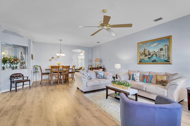 living area with light wood-style floors, baseboards, visible vents, and ceiling fan with notable chandelier