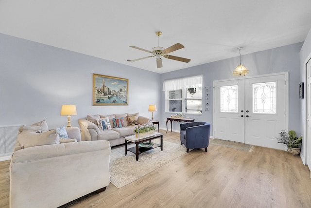 living area featuring french doors, visible vents, light wood-style floors, a ceiling fan, and baseboards