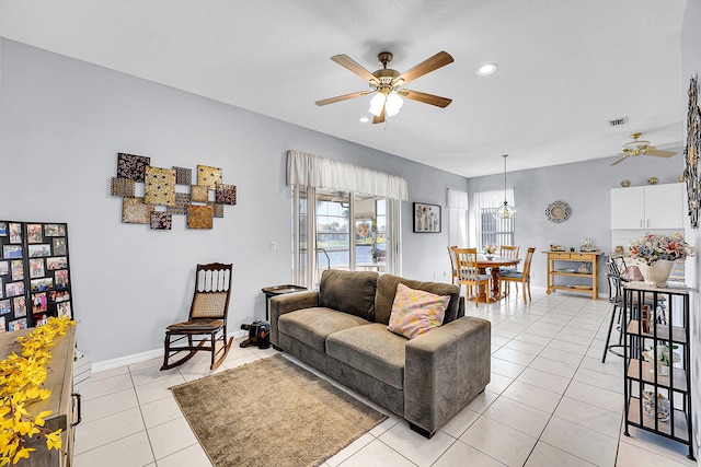 living room featuring light tile patterned floors, baseboards, visible vents, a ceiling fan, and recessed lighting