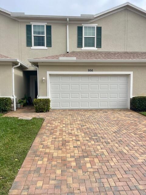 view of front of home featuring a garage, decorative driveway, and stucco siding