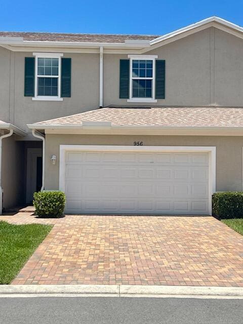 956 NE Trailside Run, Port Saint Lucie, FL 34983 - view of front facade featuring an attached garage, stucco siding, and decorative driveway