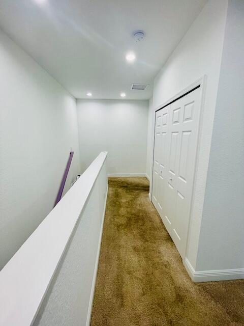 hallway with recessed lighting, visible vents, an upstairs landing, baseboards, and carpet