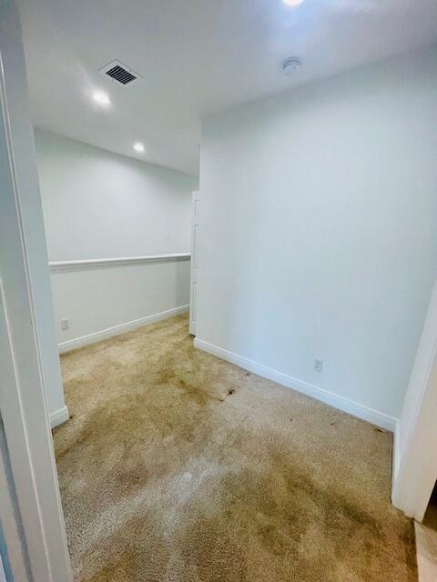 below grade area with carpet floors, visible vents, and baseboards