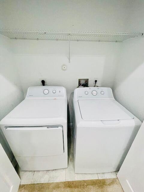 clothes washing area with laundry area and washer and clothes dryer