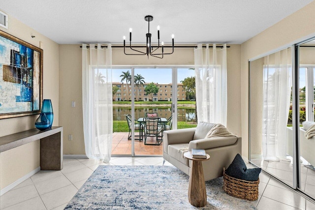 living area featuring a notable chandelier, a textured ceiling, baseboards, and tile patterned floors