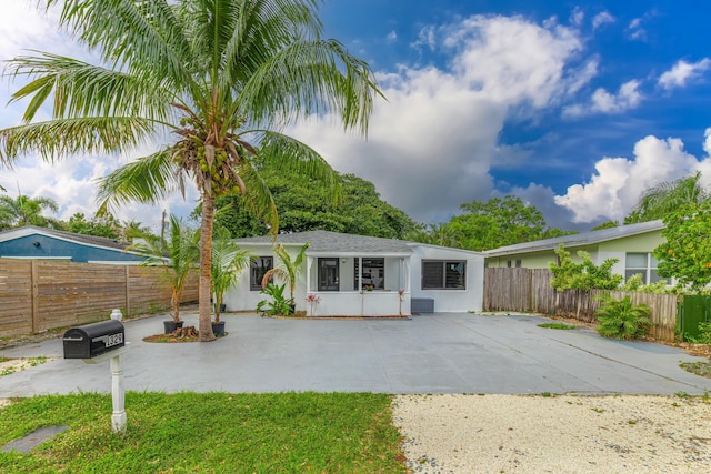 view of front of house with fence private yard, a patio, and stucco siding