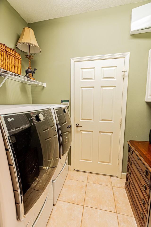 washroom with light tile patterned floors, laundry area, separate washer and dryer, and an AC wall unit