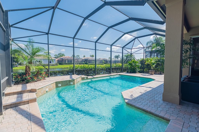 outdoor pool with a patio area, glass enclosure, and a residential view