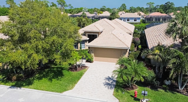 view of front facade with a residential view, a garage, stucco siding, a tile roof, and driveway