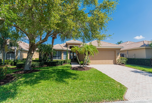 single story home featuring a garage, a front lawn, a tiled roof, and driveway