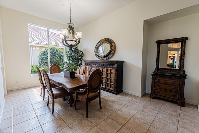 dining area with light tile patterned flooring, a notable chandelier, and baseboards