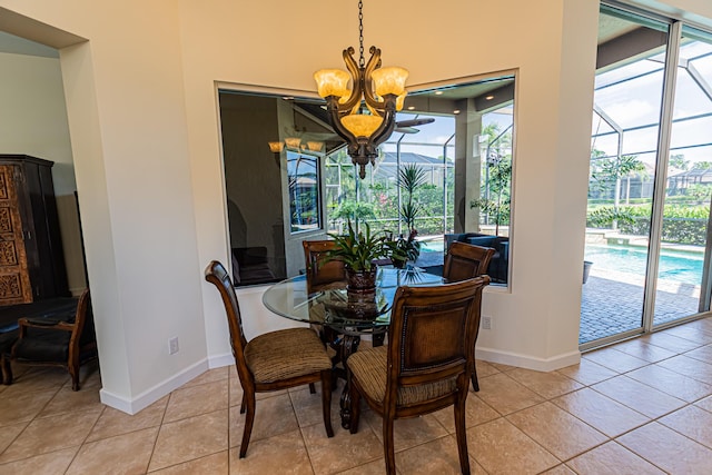 dining area featuring light tile patterned floors, a notable chandelier, a sunroom, and baseboards