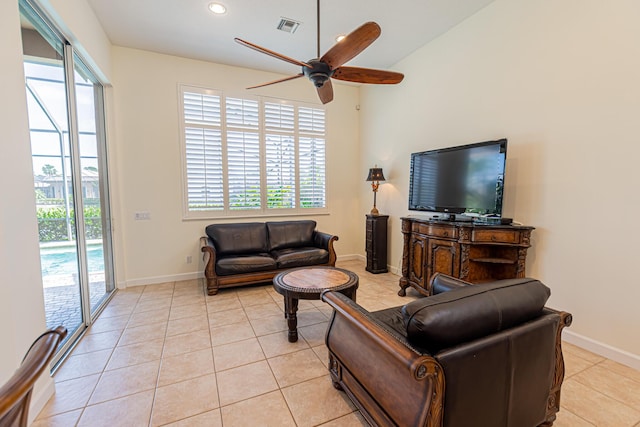 living room featuring a ceiling fan, a wealth of natural light, light tile patterned floors, and visible vents
