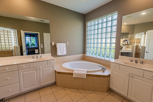 bathroom with a bath, tile patterned floors, a sink, and a wealth of natural light