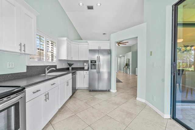 kitchen with light tile patterned floors, visible vents, dark countertops, stainless steel appliances, and a sink